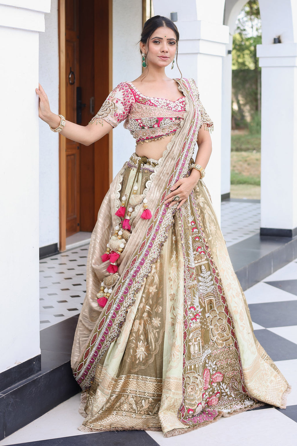 The Olive Green Shaded Brocade Silk Woven Lehenga Ensemble with Jharokha Embroidered Sweetheart Blouse and Attached Organza Dupatta