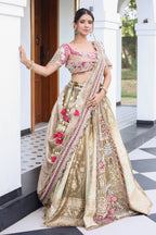 The Olive Green Shaded Brocade Silk Woven Lehenga Ensemble with Jharokha Embroidered Sweetheart Blouse and Attached Organza Dupatta