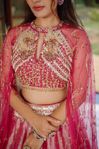 The Fuchsia Pink Ombre Tissue Lehenga Ensemble with High-Neck Keyhole Blouse and Floor-Length Feather Cape Sleeves
