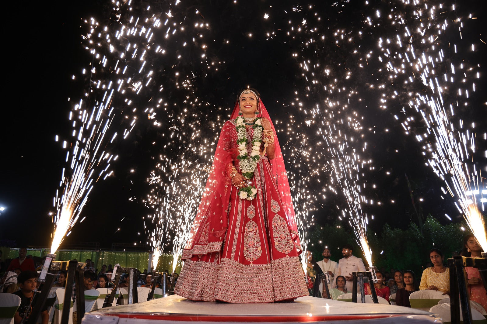 Asopalav bride in a red bridal lehenga beneath celebratory lights